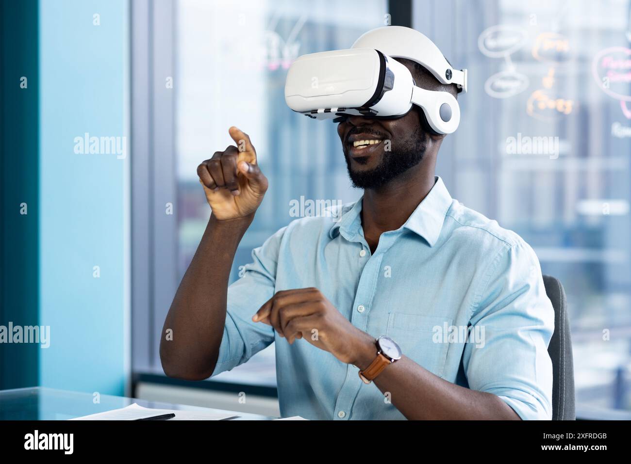 Using VR headset, man interacting with virtual environment in modern office Stock Photo