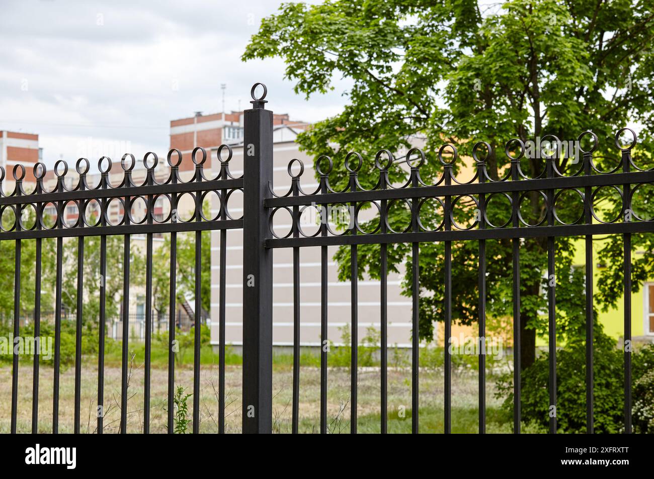 Metal fence in the city park. Decorative black iron guardrail for protection, close up Stock Photo