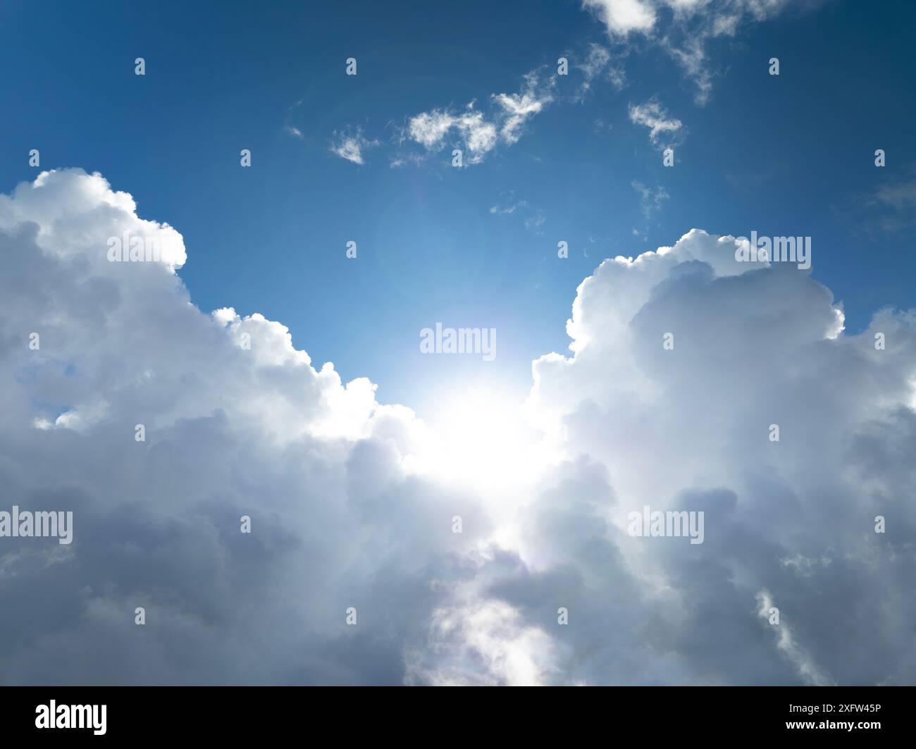 The sun shining through the puffy clouds Stock Photo