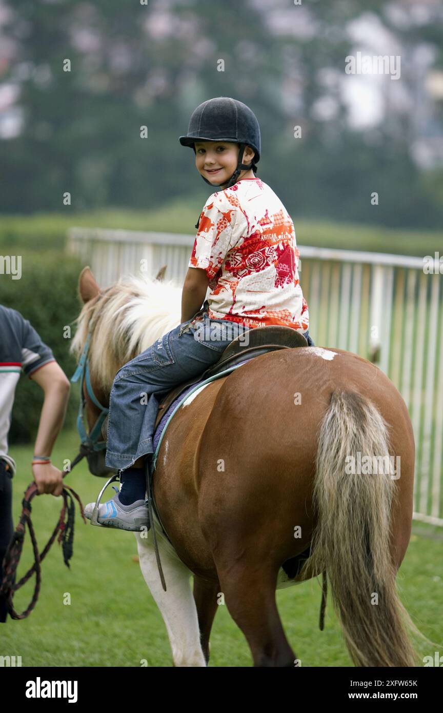 8 year old boy riding horse in the Lasarte racetrack, Donostia (San Sebastián). Guipúzcoa, Euskadi. Spain Stock Photo