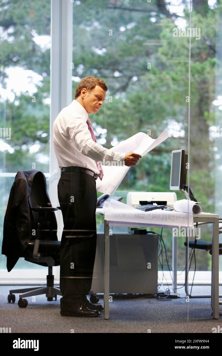 Architect with blueprints in office Stock Photo