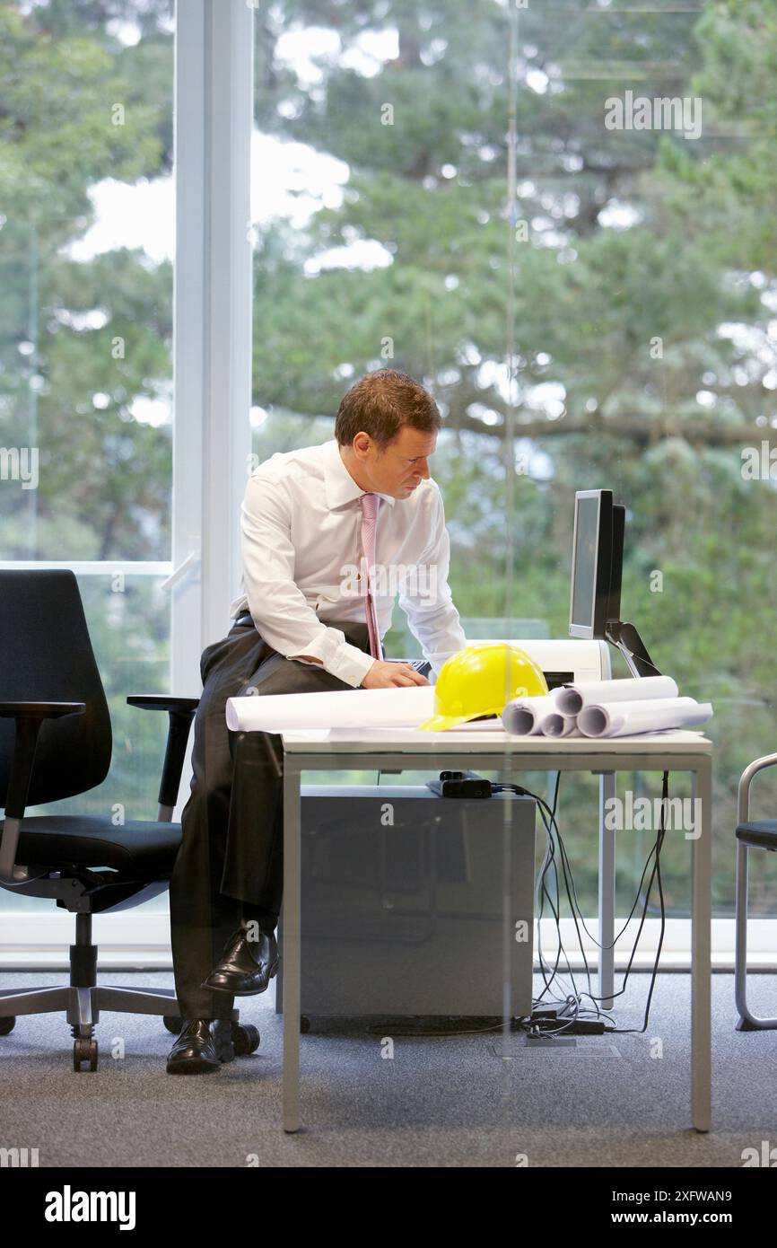 Architect with blueprints in office Stock Photo