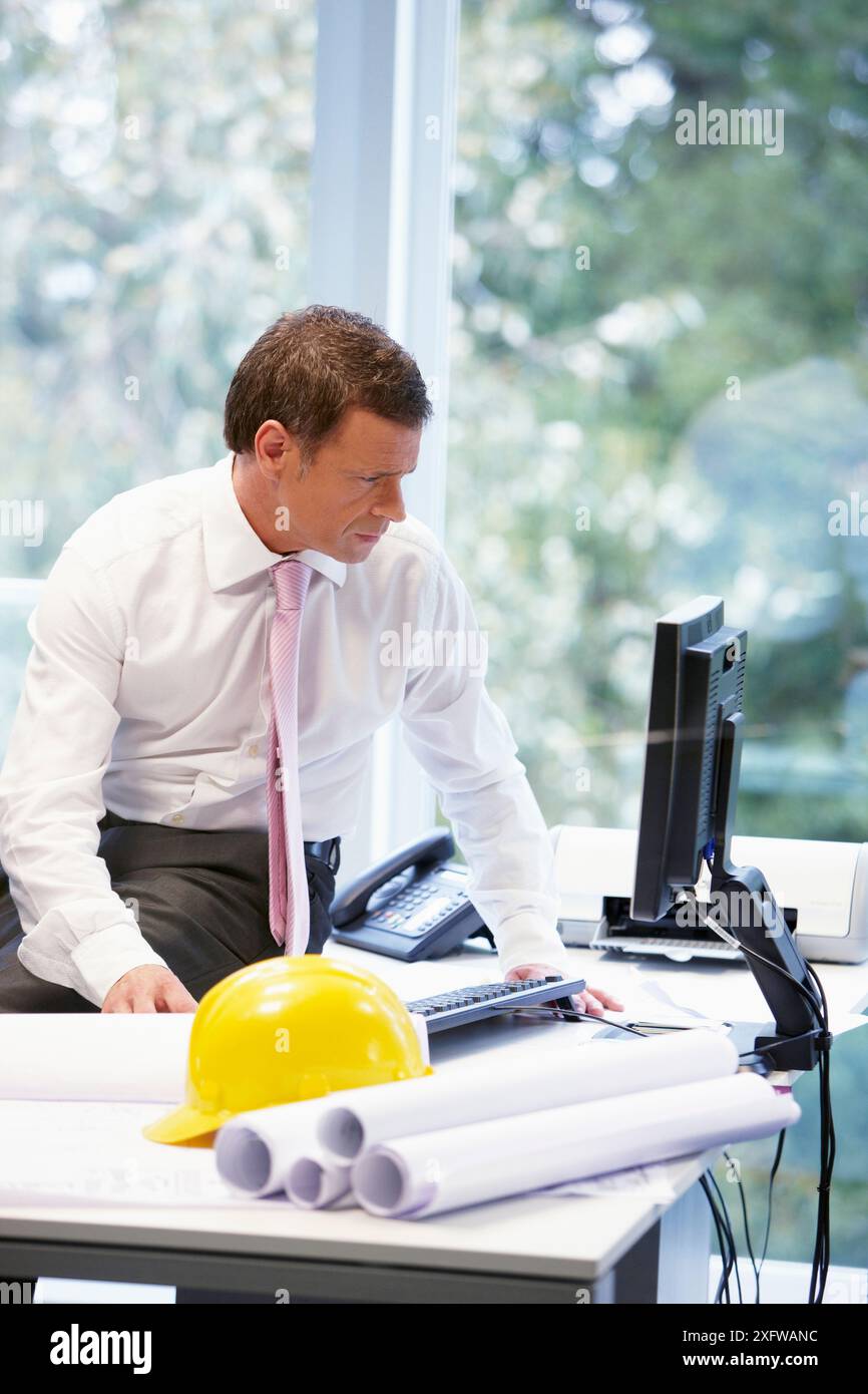 Architect with blueprints in office Stock Photo