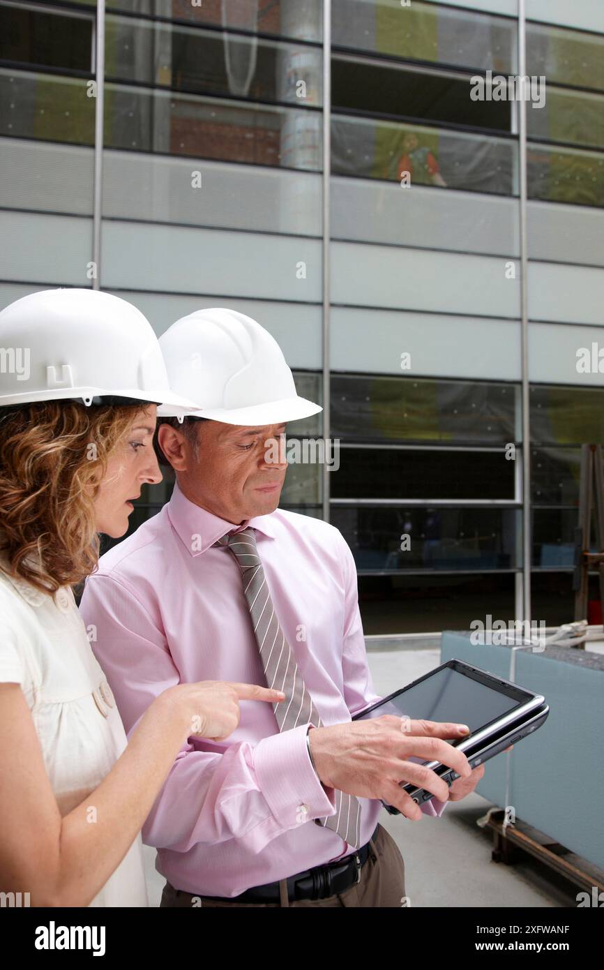 Architect and client with tablet PC in construction site Stock Photo