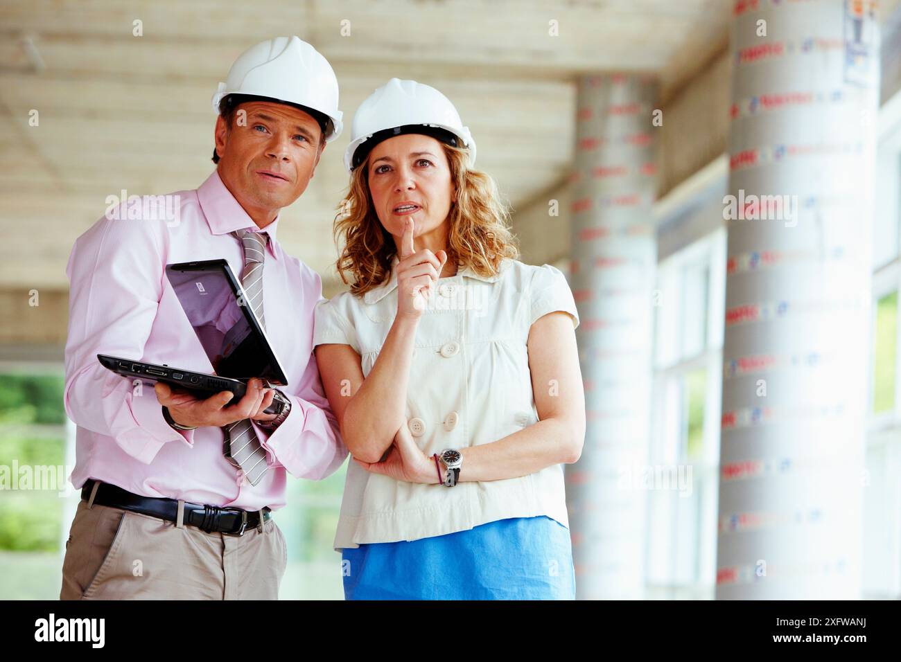 Architect and client with tablet PC in construction site Stock Photo