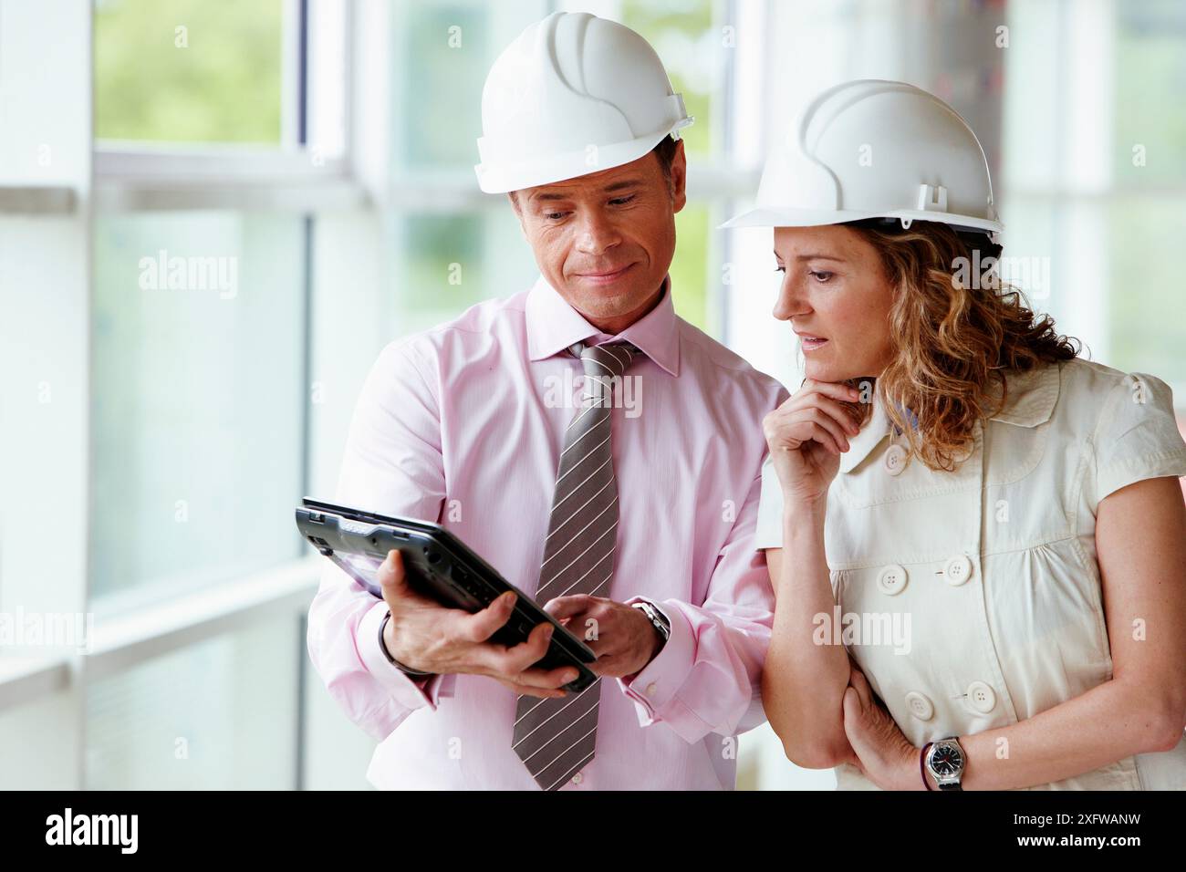 Architect and client with tablet PC in construction site Stock Photo