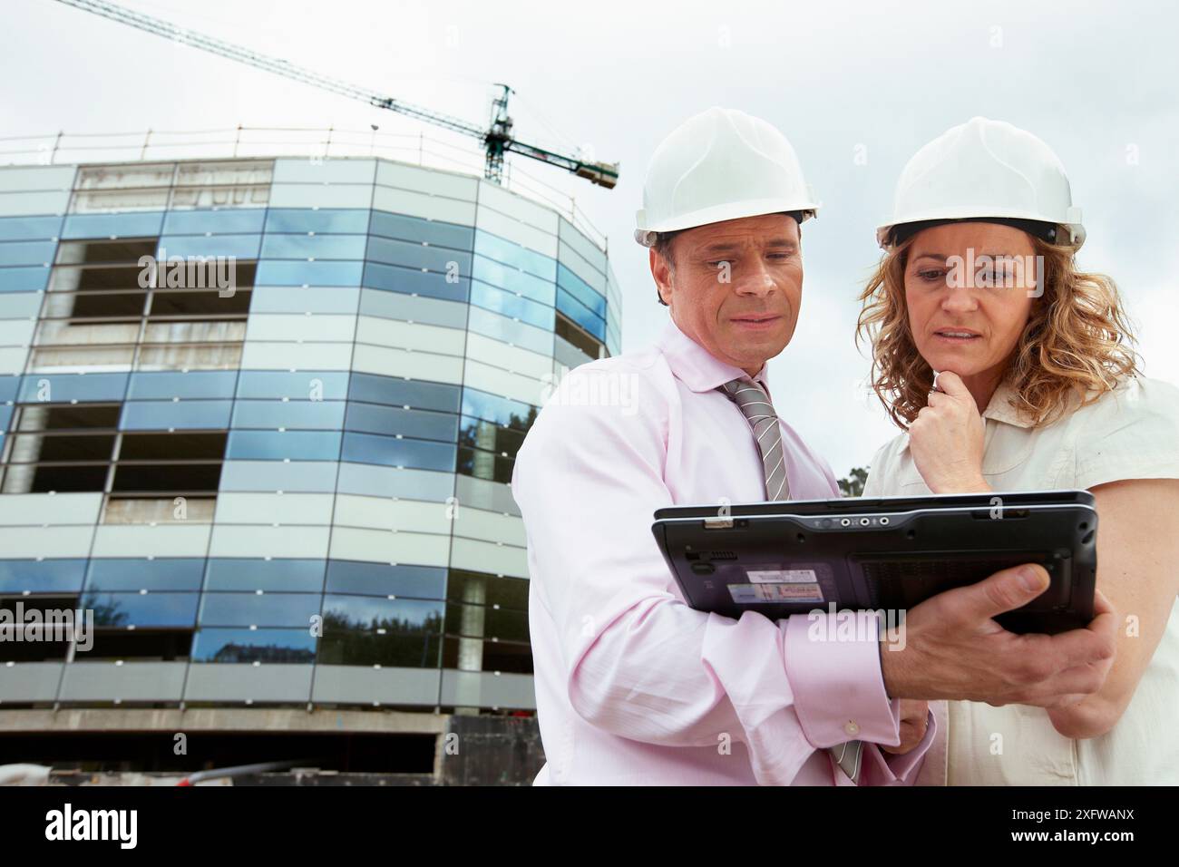 Architect and client with tablet PC in construction site Stock Photo