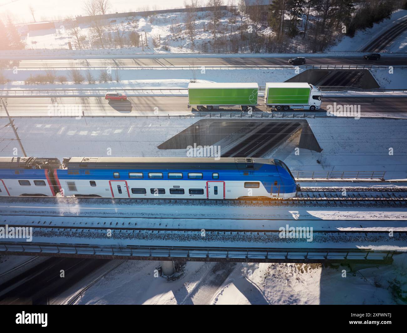 Drone view of truck and cars on overpass near train amidst snow Stock Photo