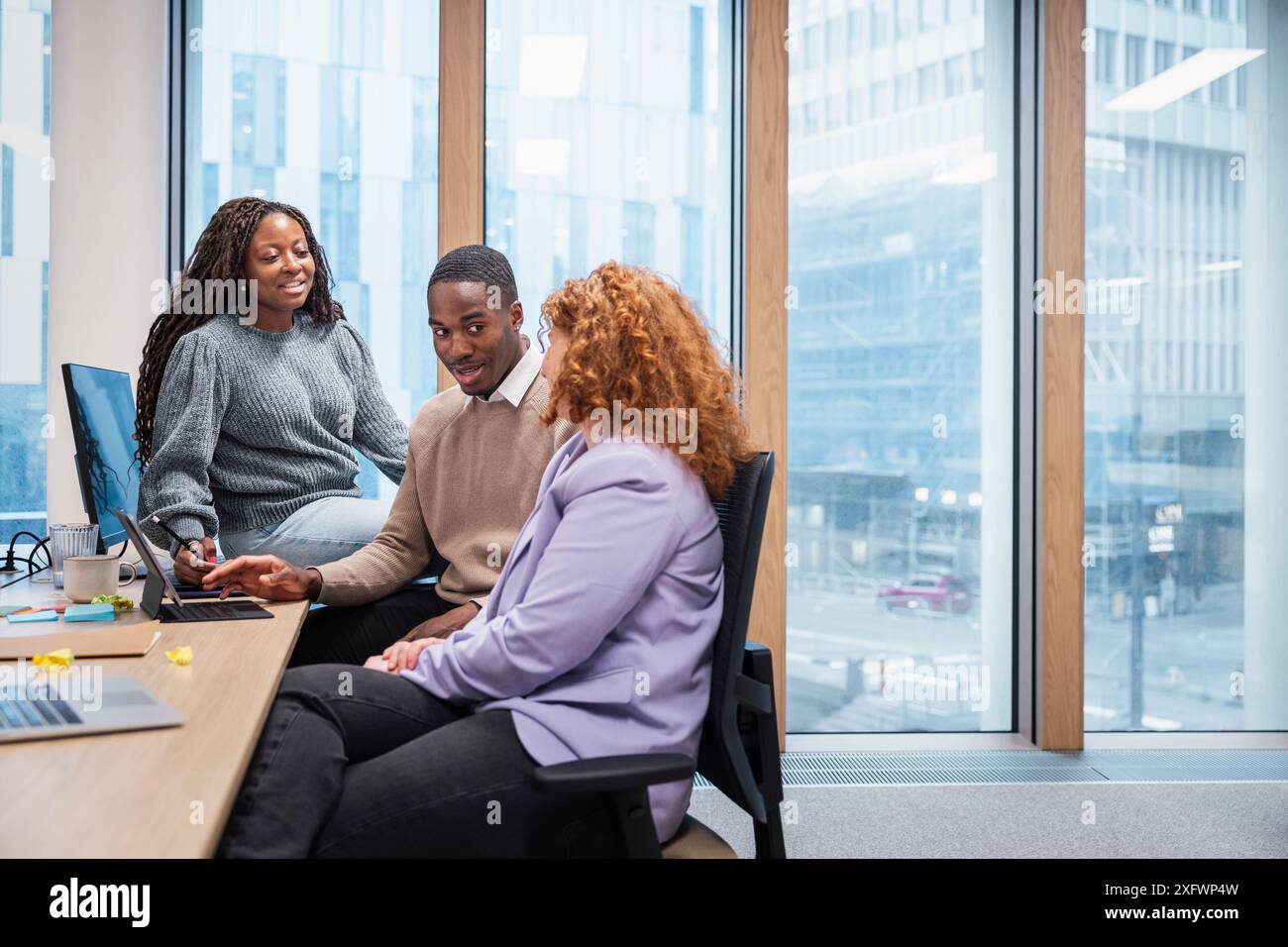 Business colleagues discussing ideas while using laptop in office Stock Photo