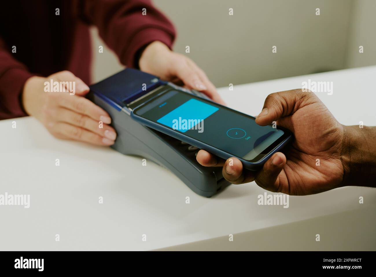 Male hand holding black phone with accepted payment, female manicured hand touching payment terminal Stock Photo