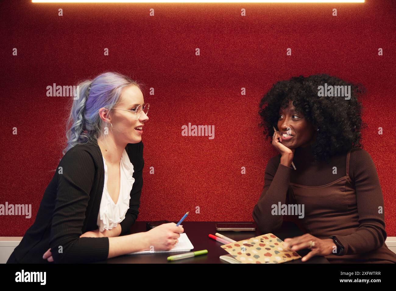 Multiracial female colleagues discussing ideas in office Stock Photo ...