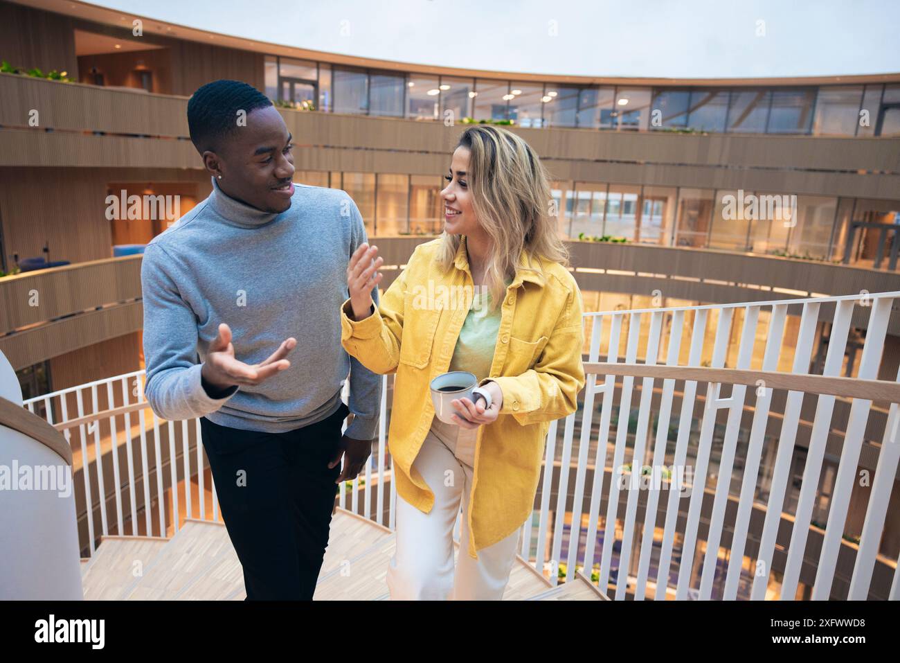 Business colleagues talking while standing on staircase Stock Photo