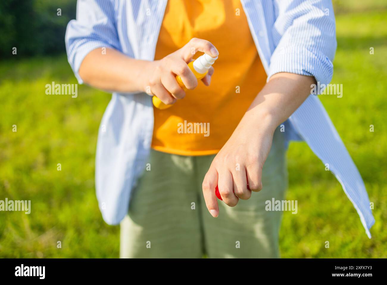 Mosquito repellent. Woman using insect repellent spray outdoors at ...
