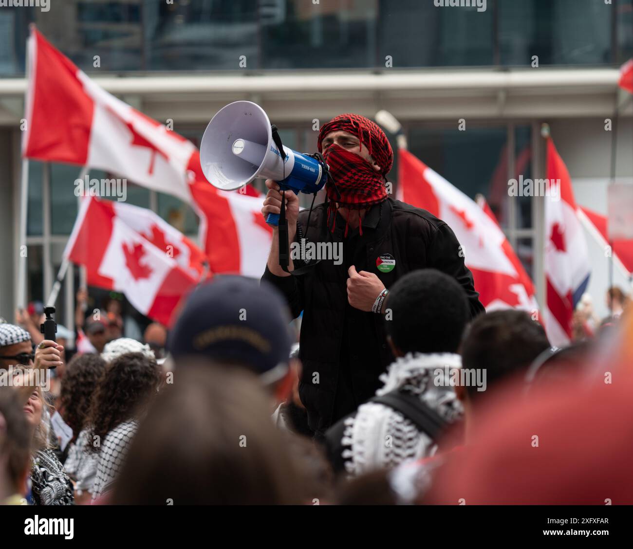 Protesters with a megaphone speaking to the crowds at the All Out For Gaza protest in the streets of Toronto, Ontario Canada. Stock Photo