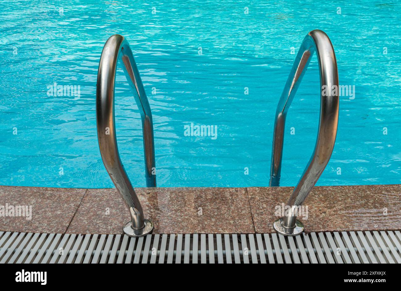 A close-up view of the stainless steel handrails of a swimming pool ...
