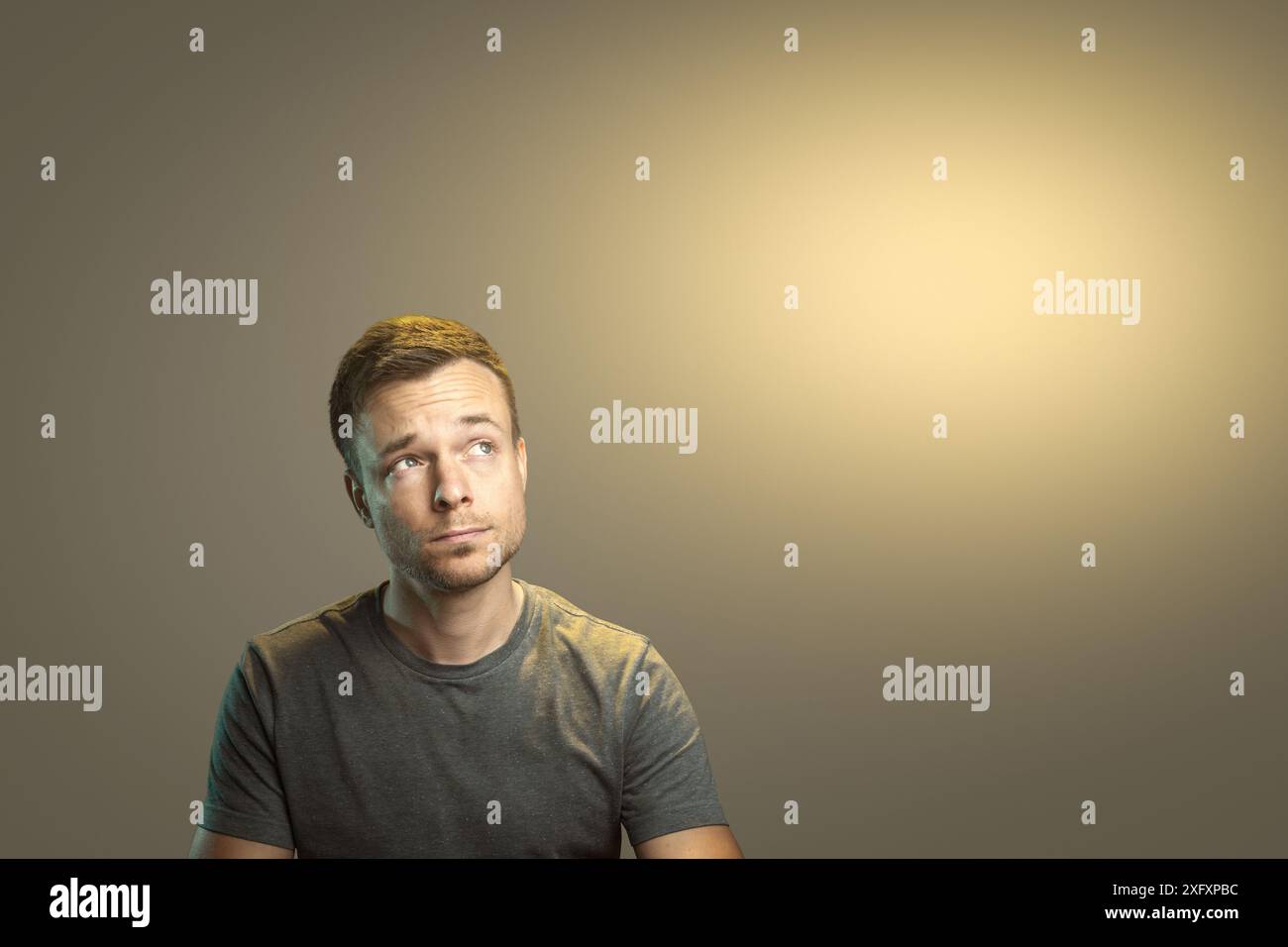 Thoughtful Man Looking Up to the Side with Copyspace Stock Photo