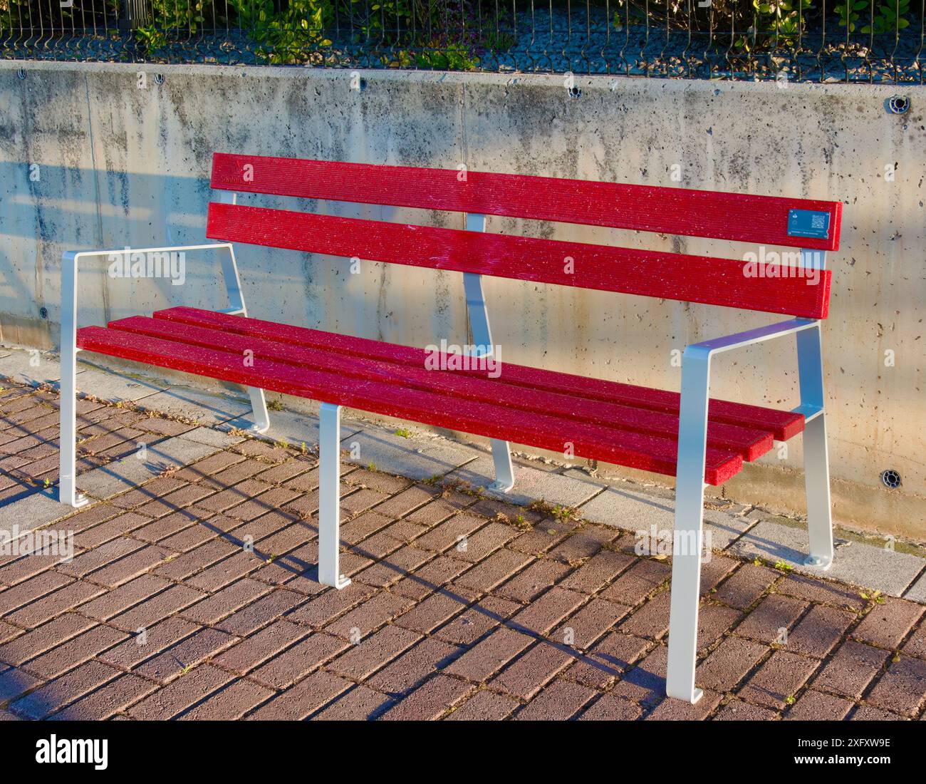 Recycled plastic debit and credit cards from Banco Santander to make public street red benches Santander Cantabria Spain Stock Photo