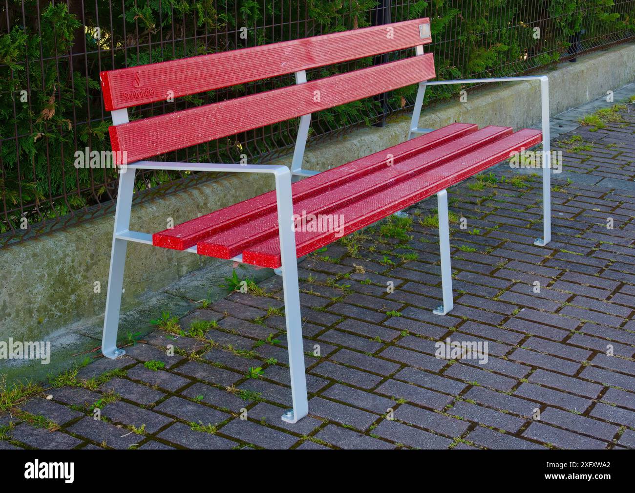 Recycled plastic debit and credit cards from Banco Santander to make public street red benches Santander Cantabria Spain Stock Photo