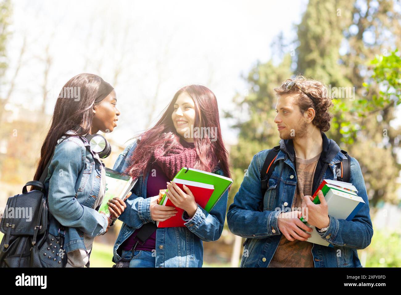 Three young students in the outdoor park. Multiracial group concept. Stock Photo