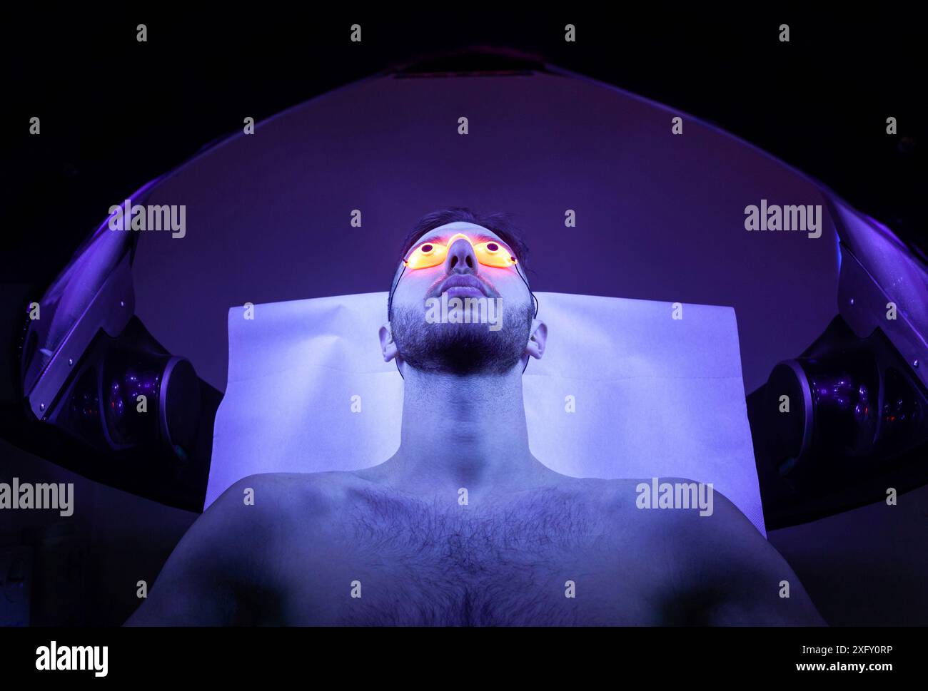 Young Thin Man At Solarium In Beauty Salon. Stock Photo