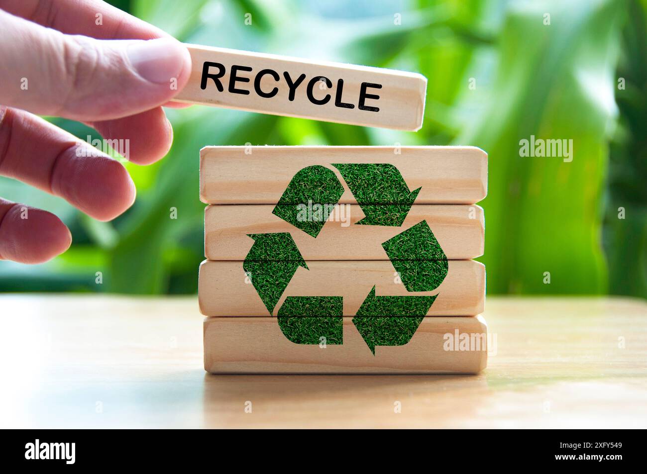 Hand placing wooden block with text recycle. Recycle concept with recycle symbol. Stock Photo