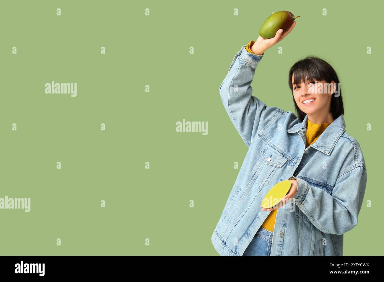 Beautiful young woman with ripe mangoes on green background Stock Photo ...