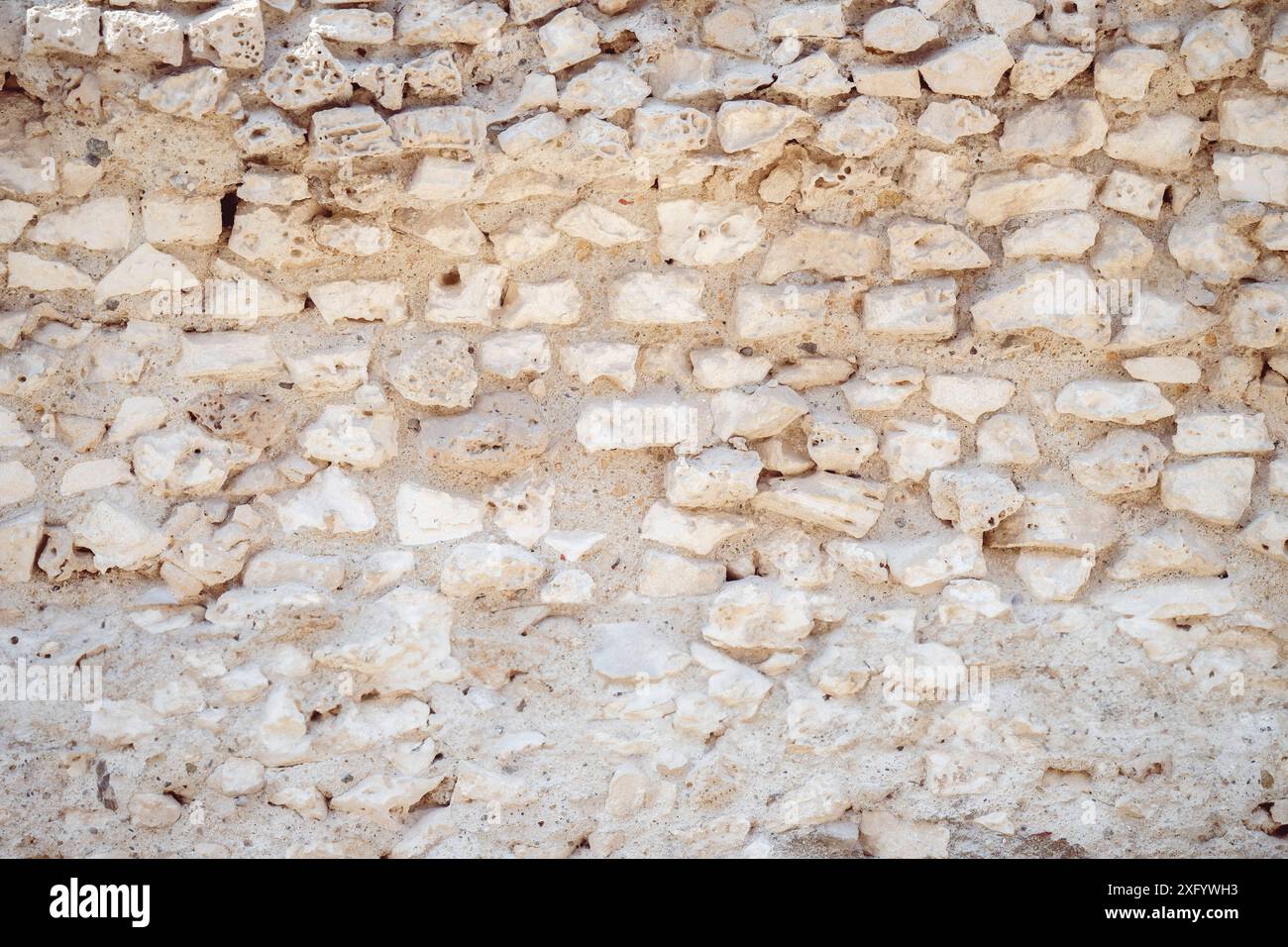 Bumpy Rocks Wall An ancient stone wall with irregularly shaped rocks and a rough texture ...