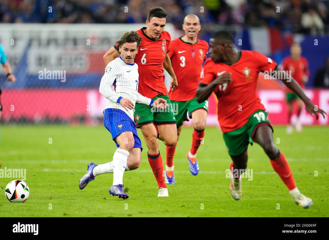 France's Antoine Griezmann (left) battles for the ball with Portugal's Joao Palhinha, Pepe and Nuno Mendes (right) during the UEFA Euro 2024, quarter-final match at the Volksparkstadion, Hamburg, Germany. Picture date: Friday July 5, 2024. Stock Photo