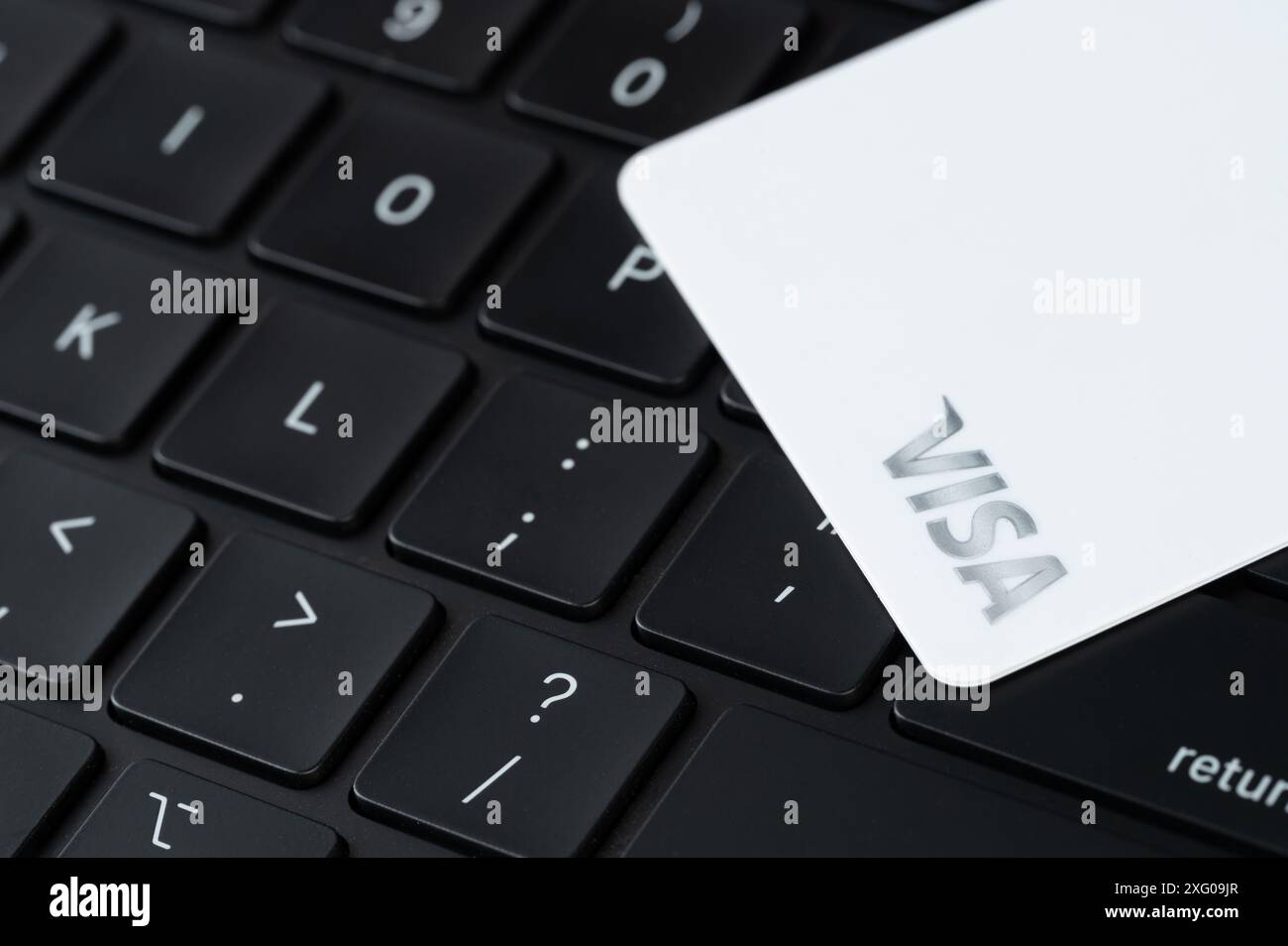 New York, USA - July 5, 2024: White visa bank card on black computer keyboard close up view Stock Photo