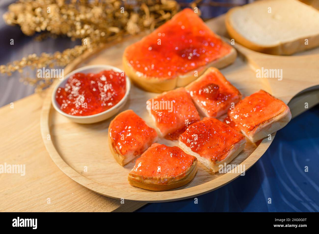 Slices of bread with strawberry jam on a wooden board. . Stock Photo