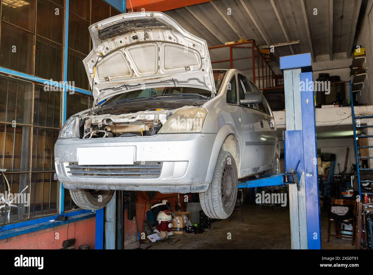 Car is lifted up on a garage lift, ready to be repaired Stock Photo - Alamy