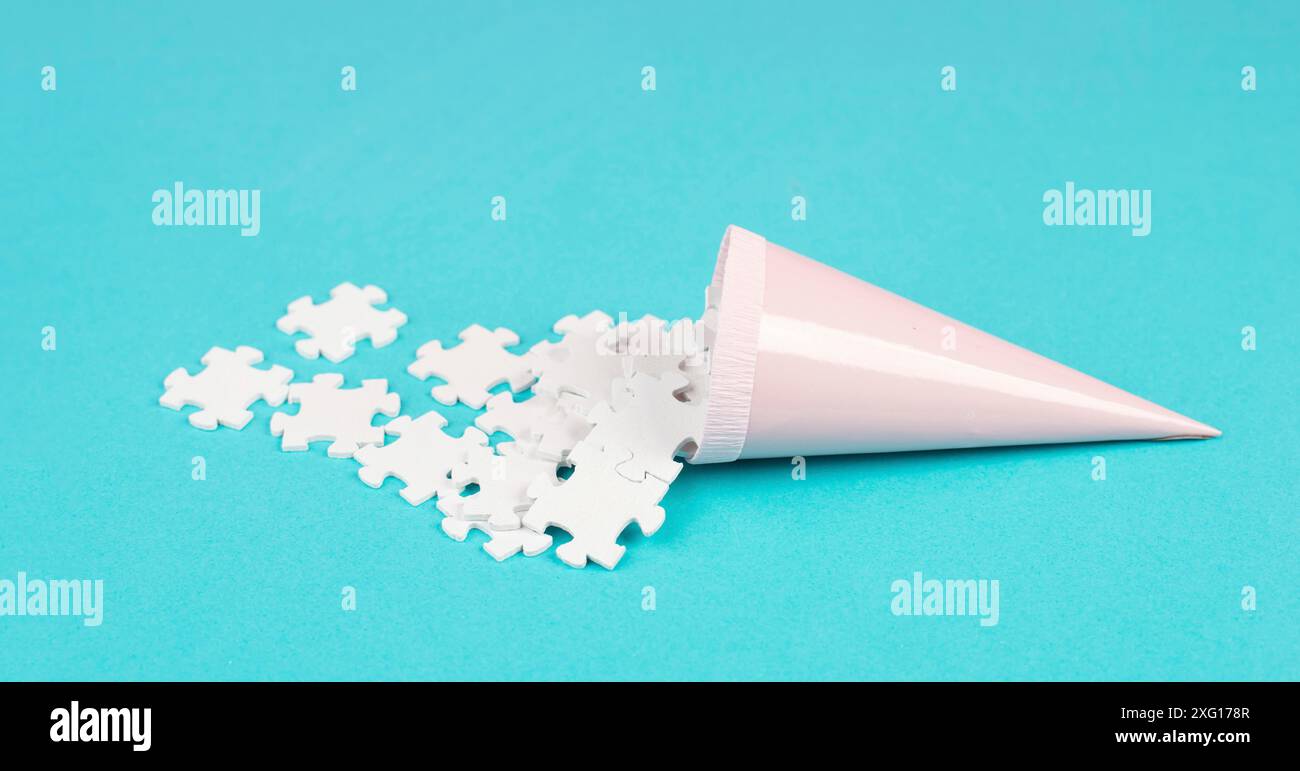 Cone with white puzzle pieces, blue background, spreading the jigsaw ...