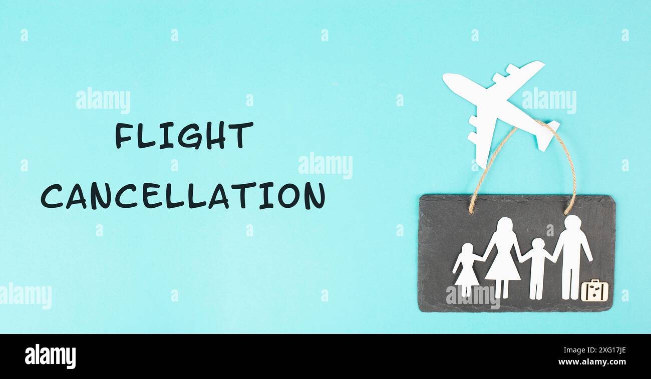 The words flight cancellation are standing the paper, airplane cut out, staff shortage at the airport, vacation delayed for family Stock Photo