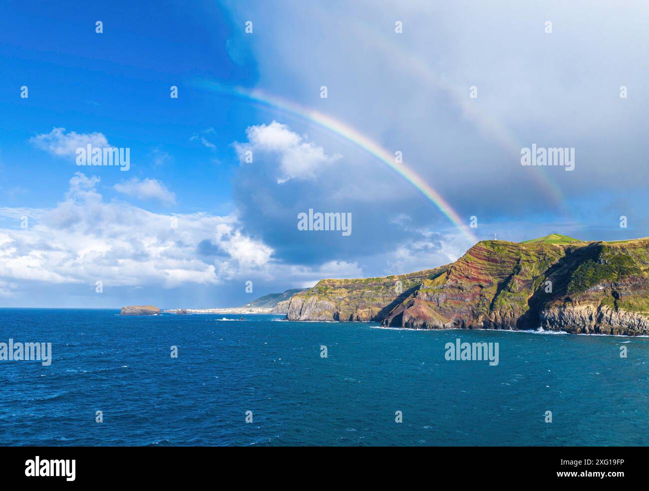 Colorful rainbow arching over the coastline of the azorean island San ...