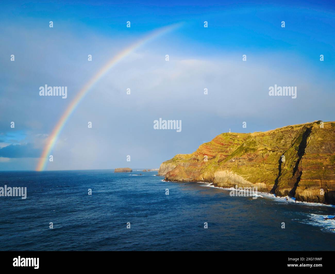 Colorful rainbow arching over the coastline of the azorean island San ...