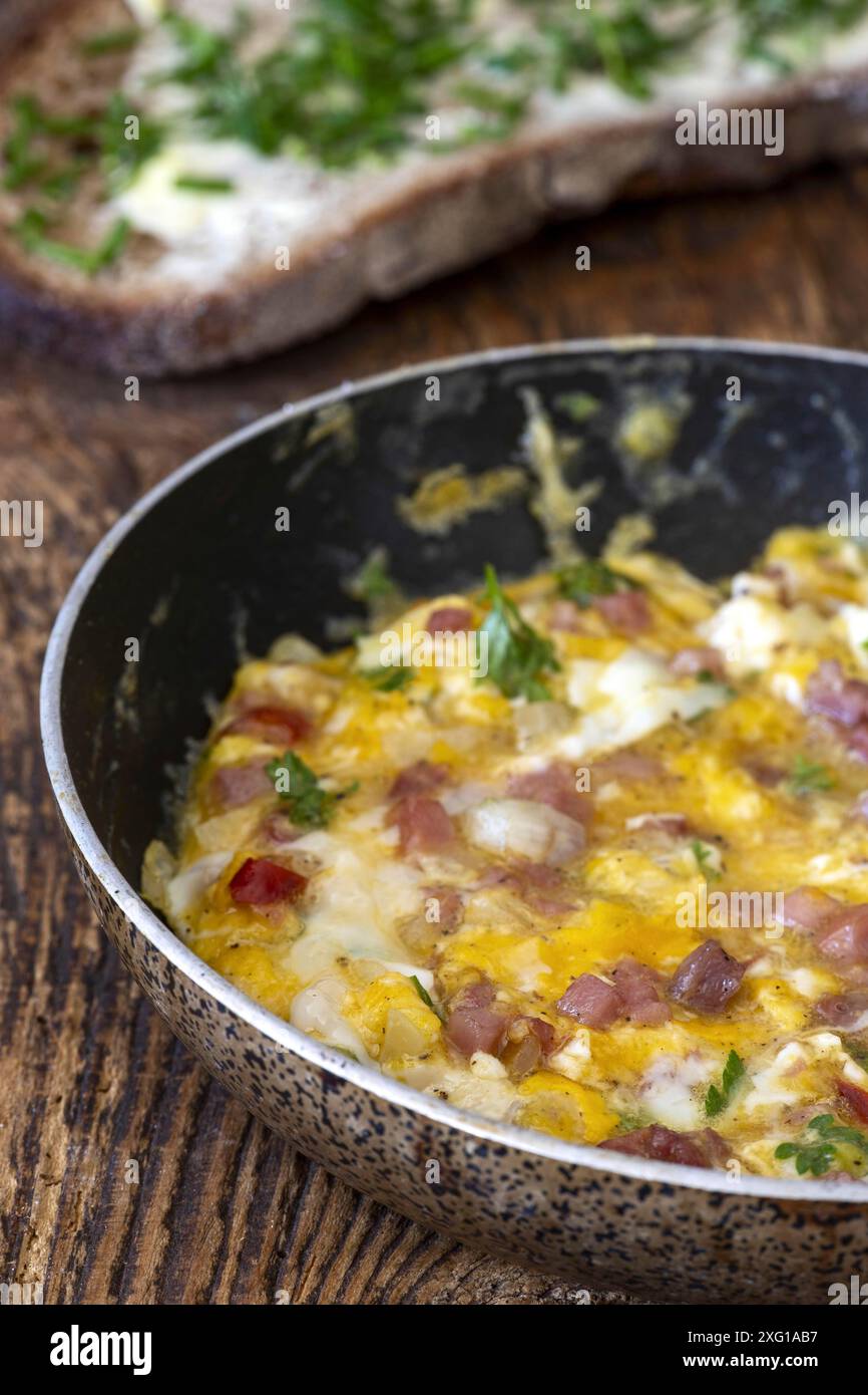 Scrambled eggs in a pan on wood Stock Photo