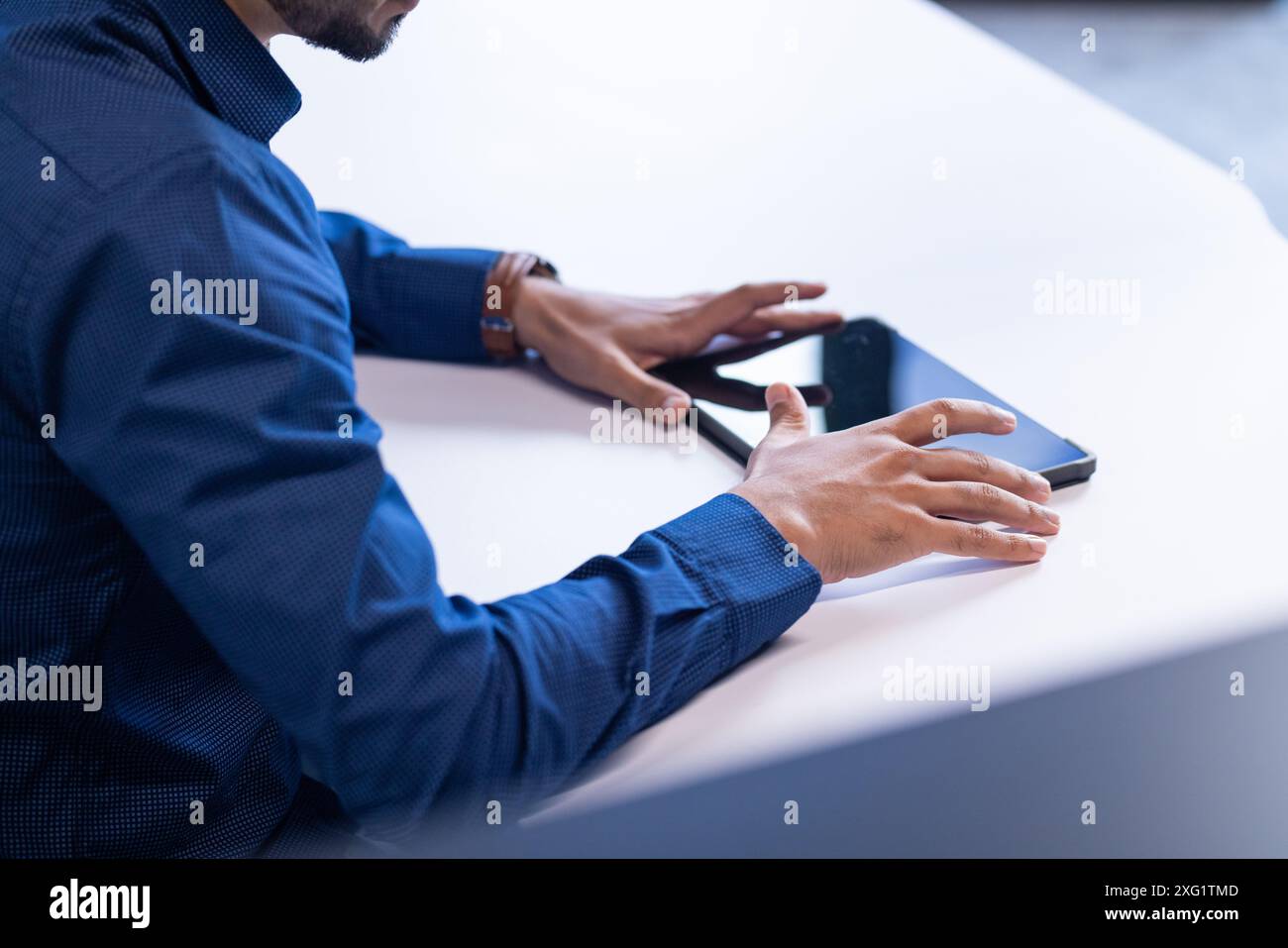Using tablet and smartphone, businessman working at desk in office, copy space Stock Photo