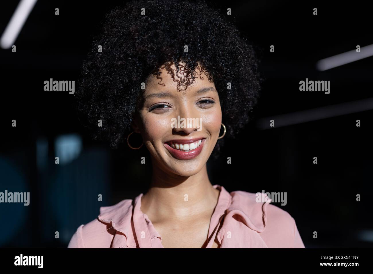 Smiling woman in business attire posing confidently in office environment Stock Photo