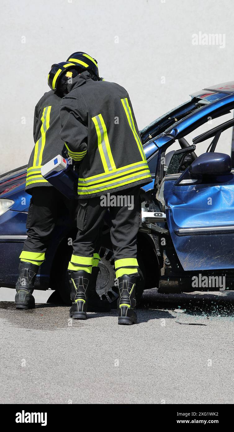 Firefighters using a hydraulic rescue tool called Jaws of Life to pry