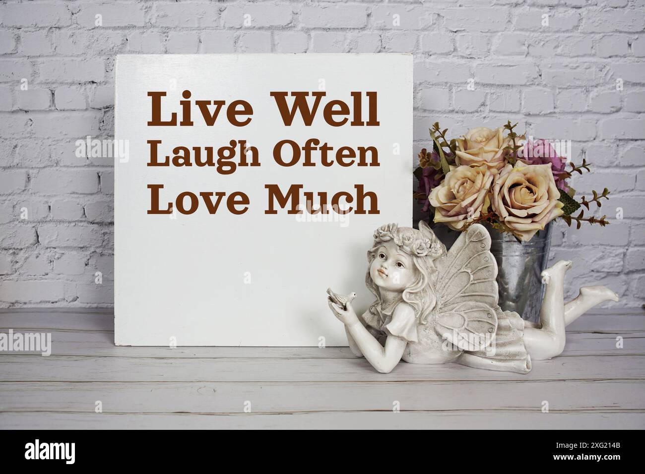 Live well laugh often love much motivational and inspiration quote with  angel ceramic doll and roses flowers in metal vase decoratiom on wooden  backgr Stock Photo - Alamy, image size:1300x956