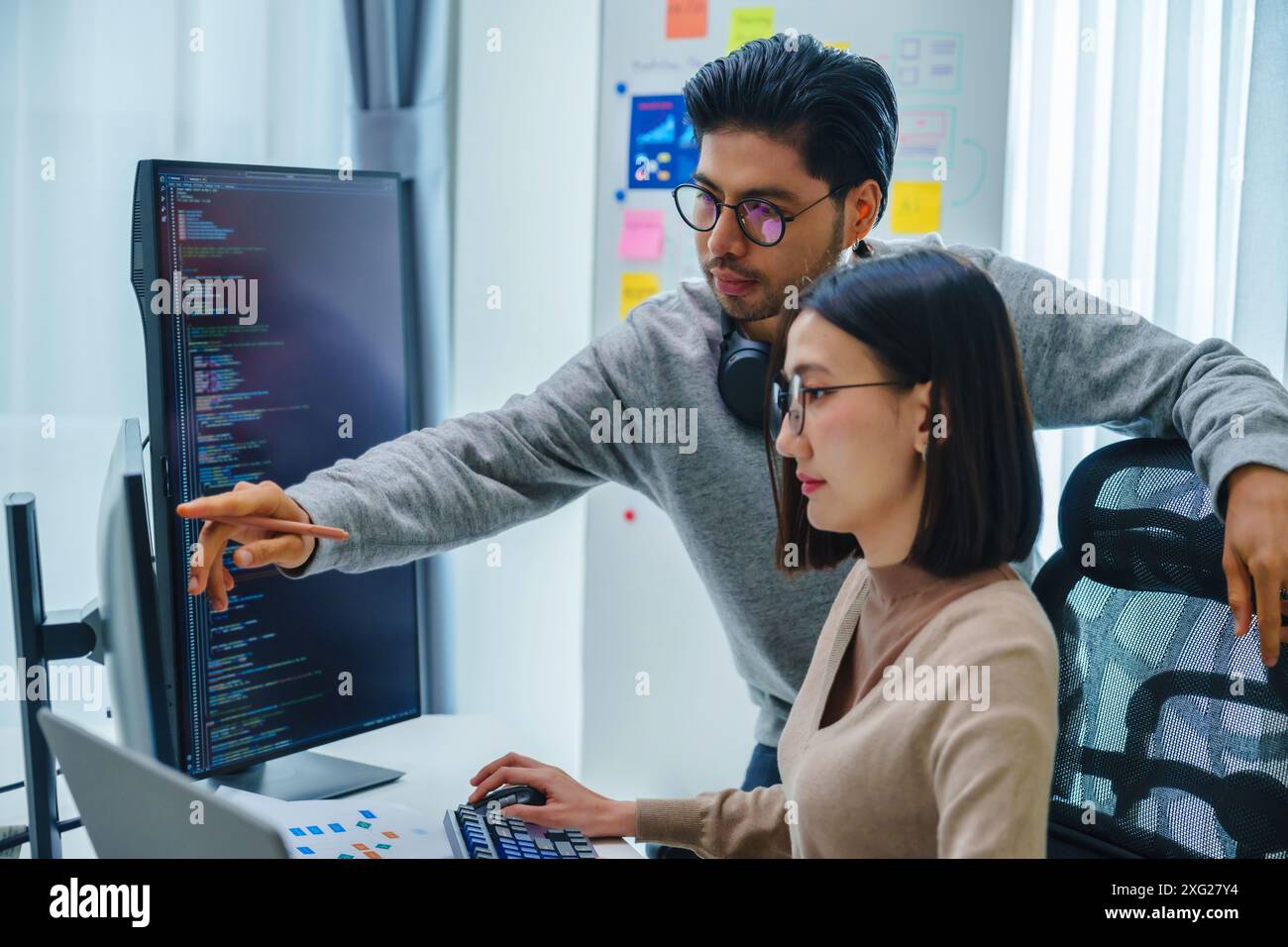 asian and Indian Developer team discussion feedback analysis coding data with software computer at office Stock Photo