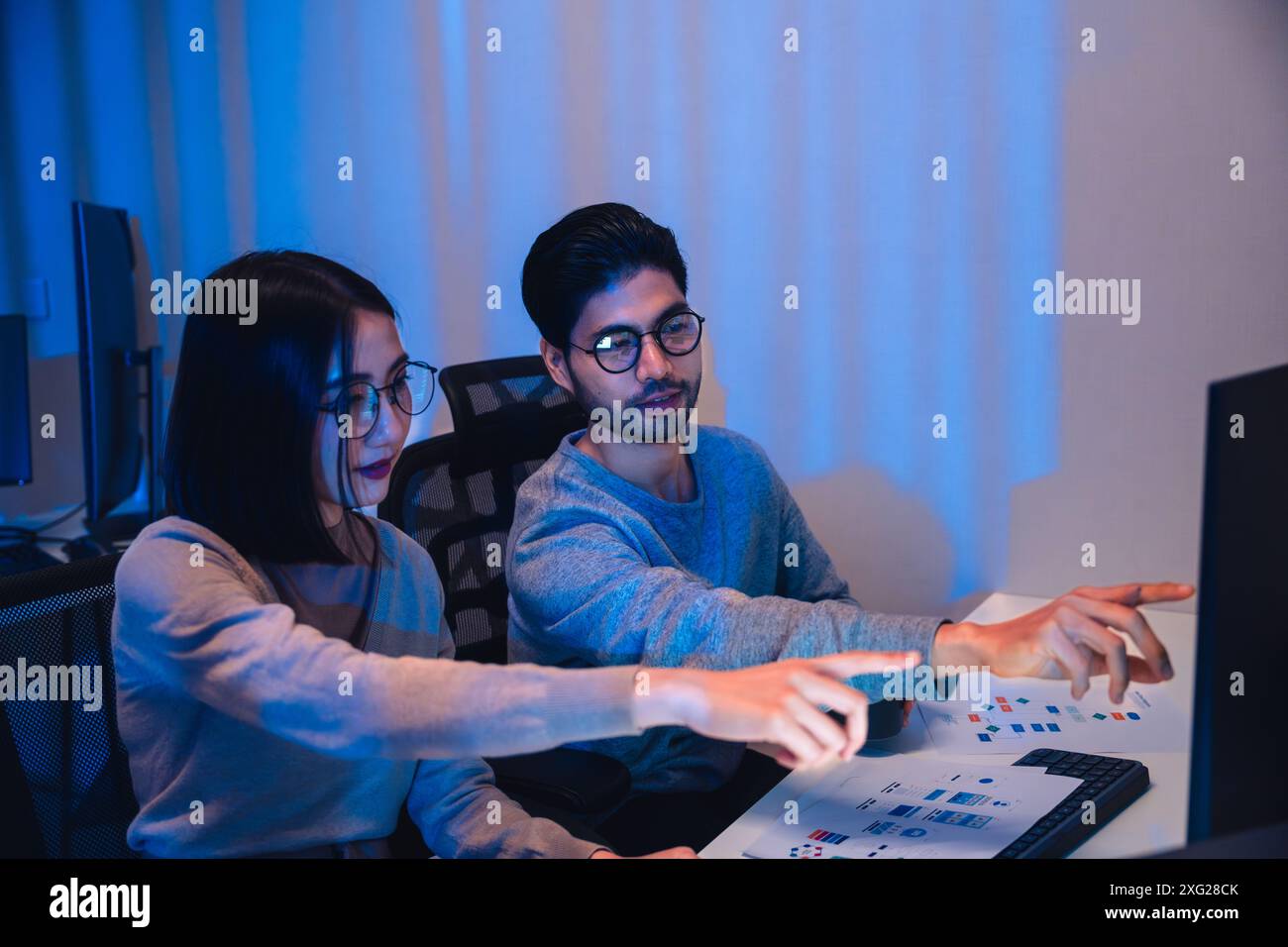 asian and Indian Developer team discussion feedback analysis coding data with software computer at office Stock Photo