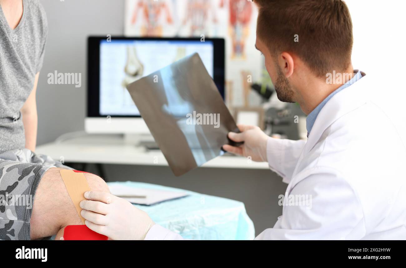 Physician doctor examining patient leg, hold x ray of bone, injury ...