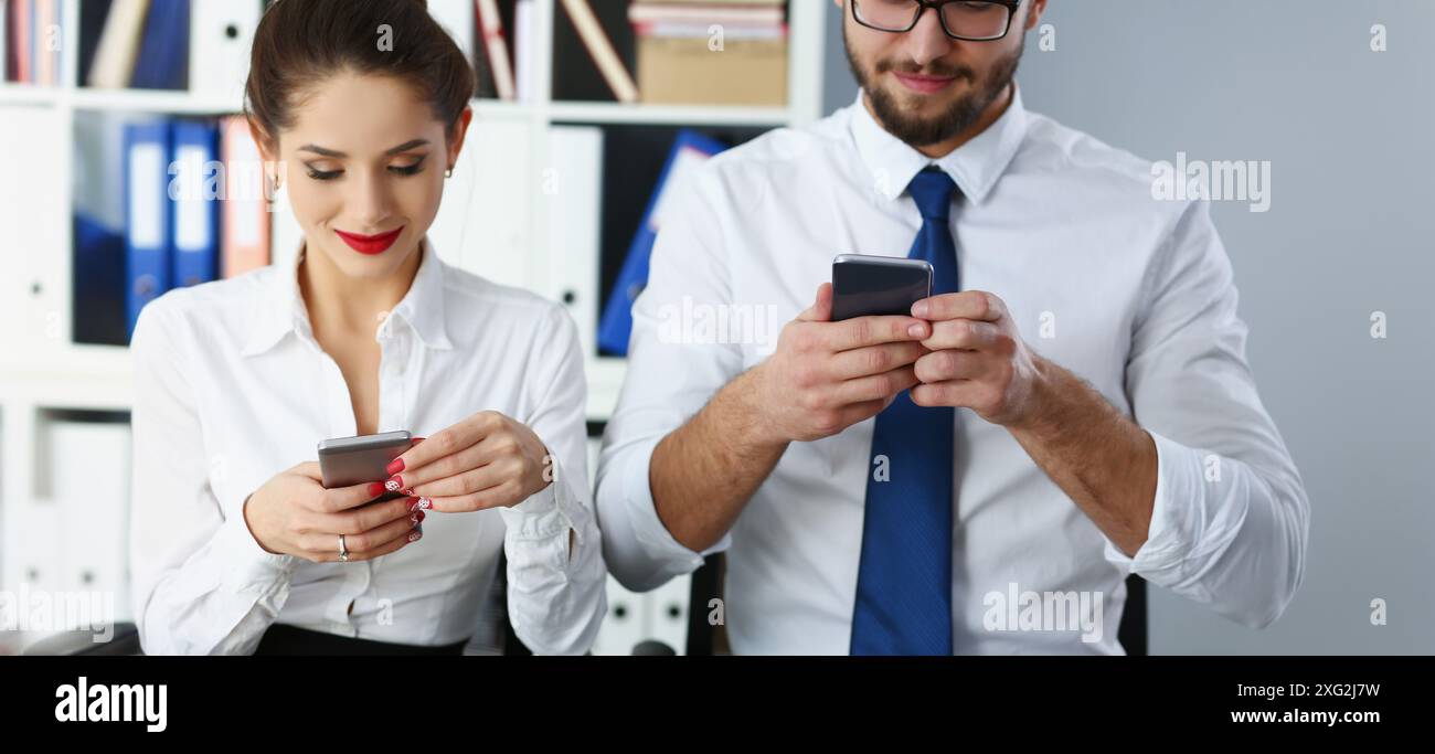 Group of people hold devices and look at phone screen in office Stock Photo