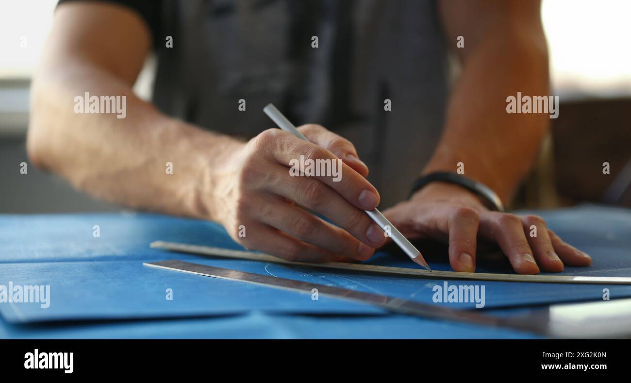 Builder man hand holding pencil and make corrections on building plan ...