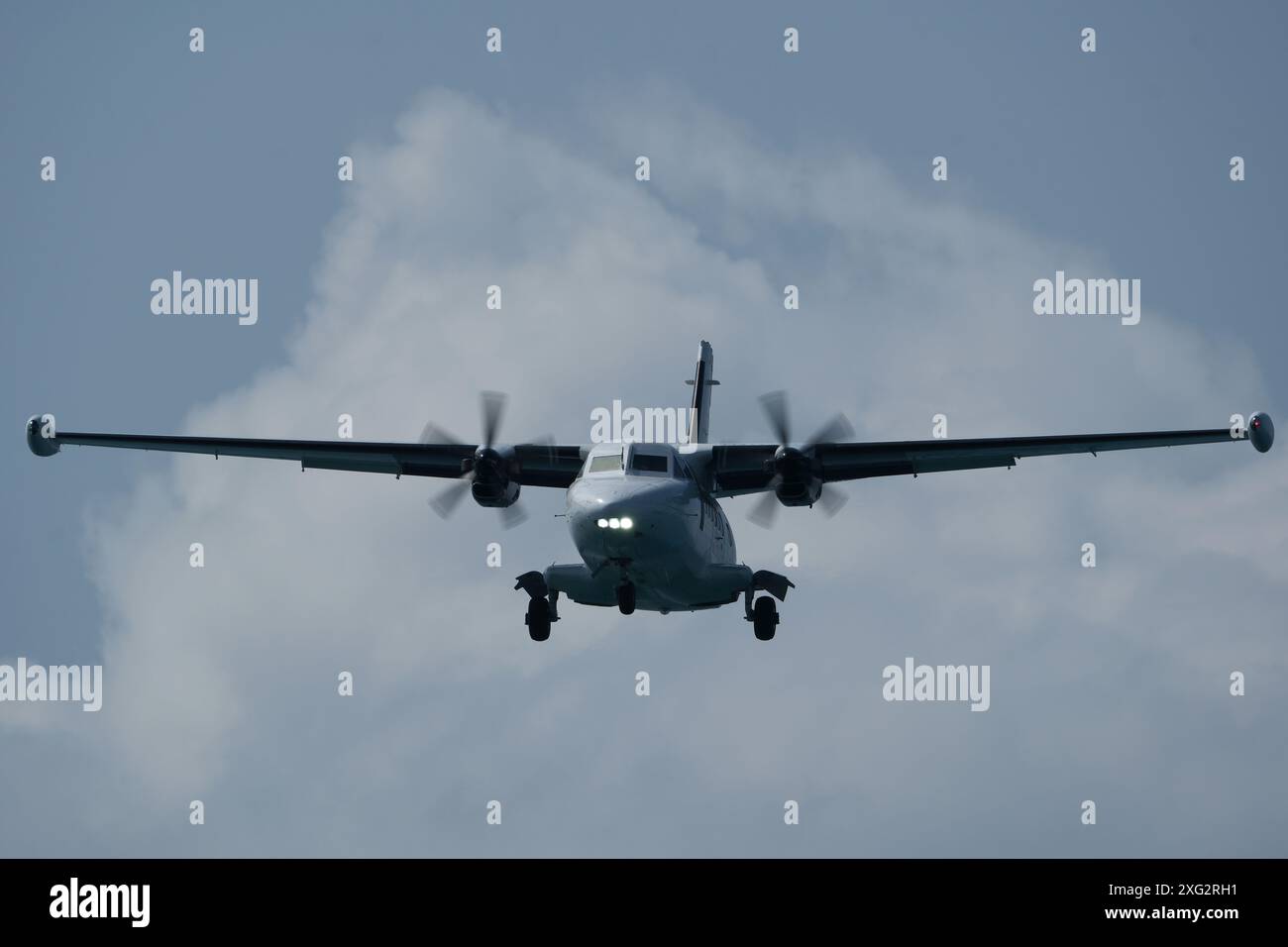 Twin-engine short-range transport aircraft in the cloudy sky. Stock Photo