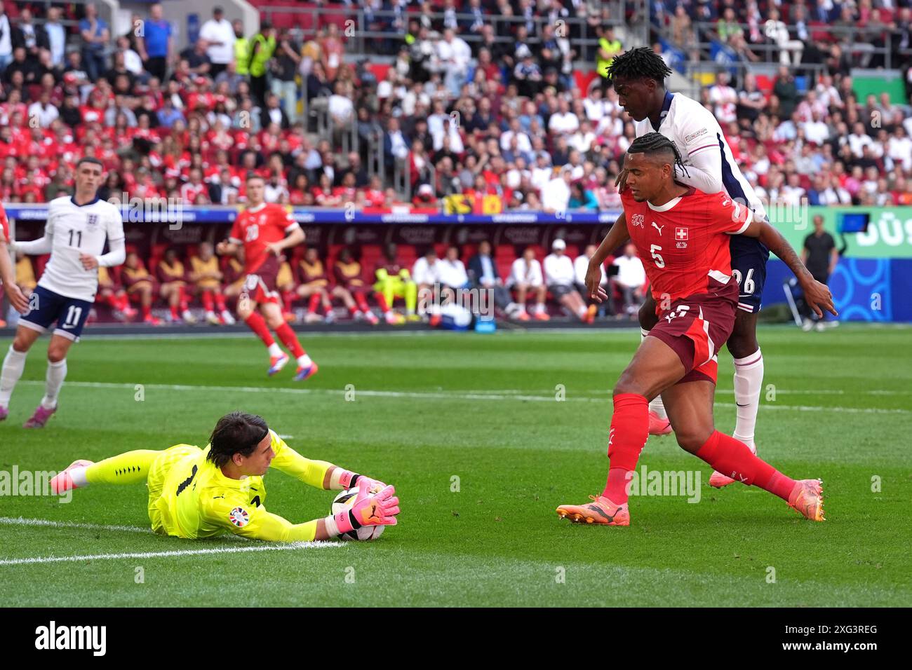 England's Kobbie Mainoo (right) sees his shot saved by Switzerland ...