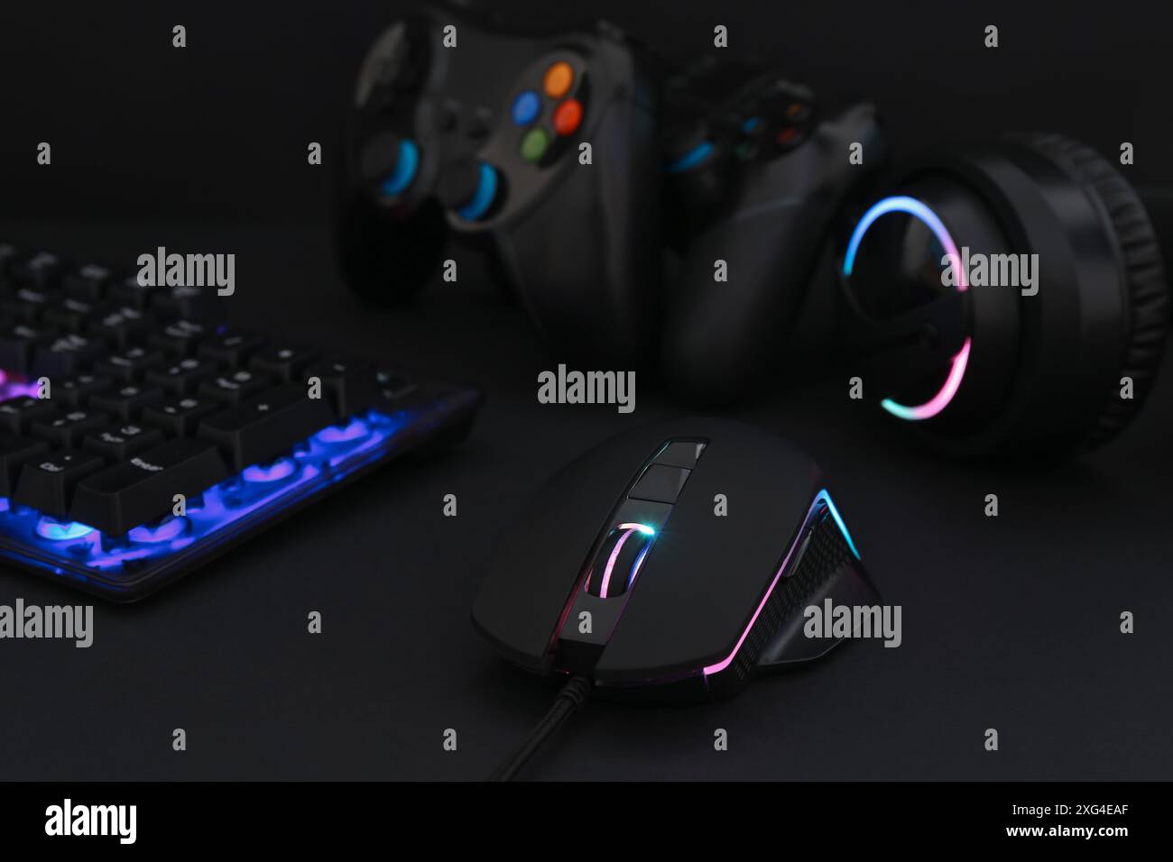 Computer mouse, headset, RGB keyboard and game controllers on black ...