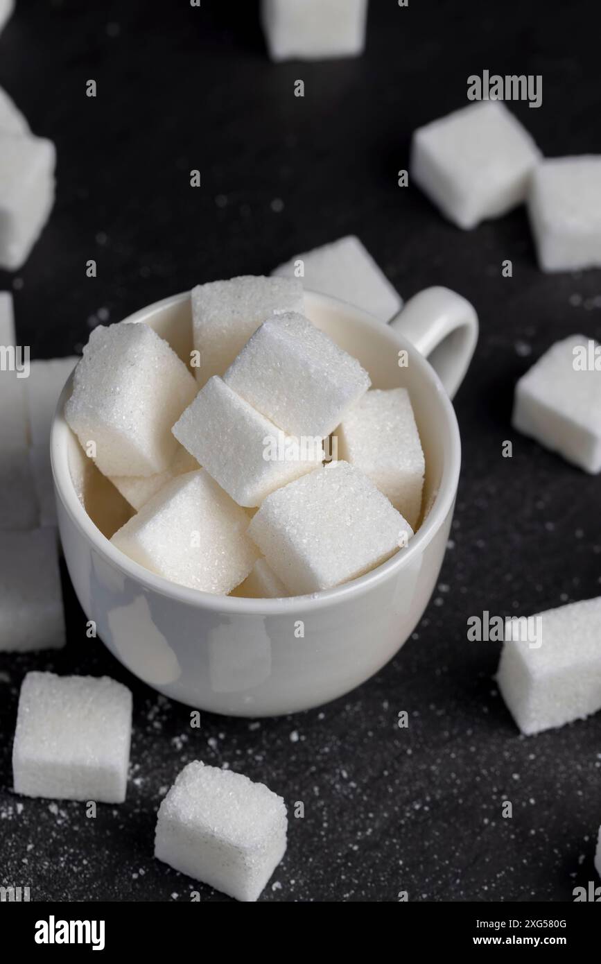 white square sugar on a black background , lump sugar in the shape of a ...