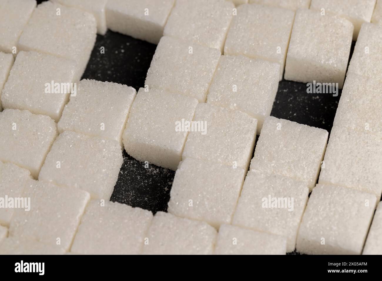 white square sugar on a black background , lump sugar in the shape of a ...